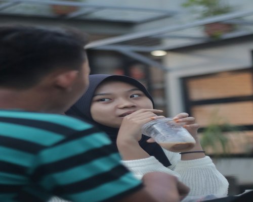 Seseorang sedang minum air putih sambil membaca